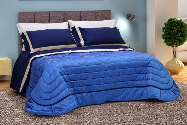 Coordinato letto composto da trapunta damasco blu e lenzuola balzate